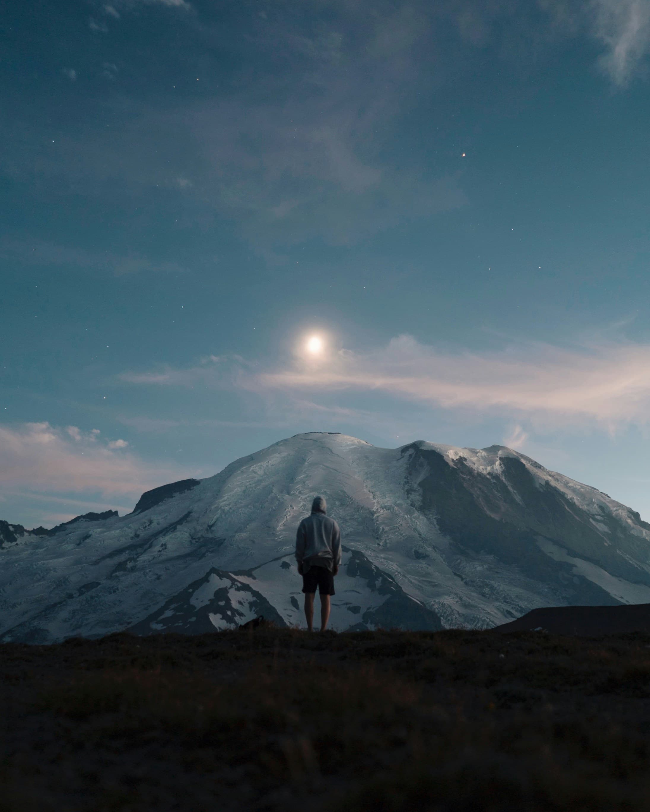 Person standing before mountain at twilight, representing the journey ahead